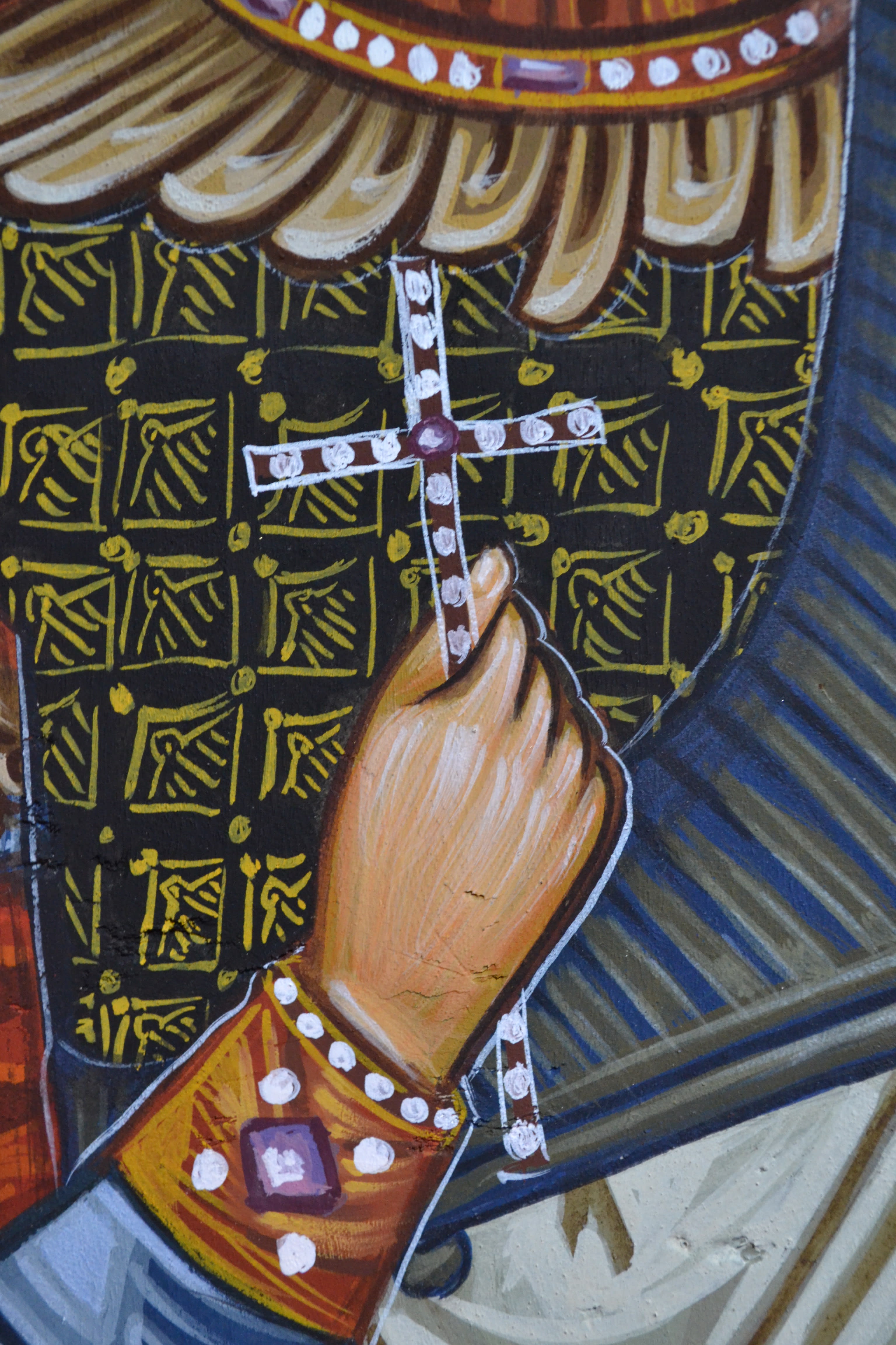 Close up detail of a Byzantine Icon of Saint George holding a cross on his right hand and showcasing the exquisite detail of his lavish clothing