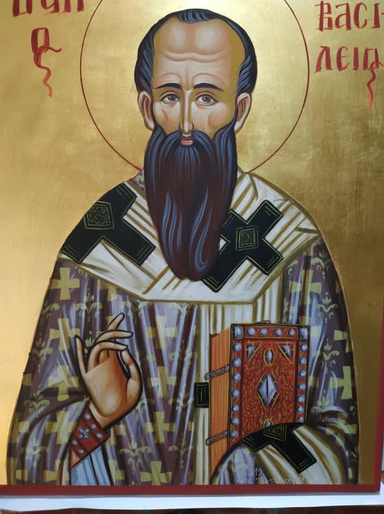 Saint Basil, blessing everyone with his right hand and holding a holy book on is left hand, while dressed lavishly